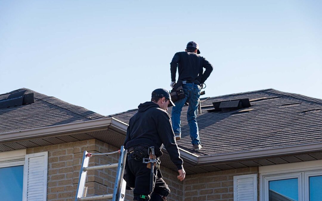 Two roofers inspecting a damaged roof in san antonio