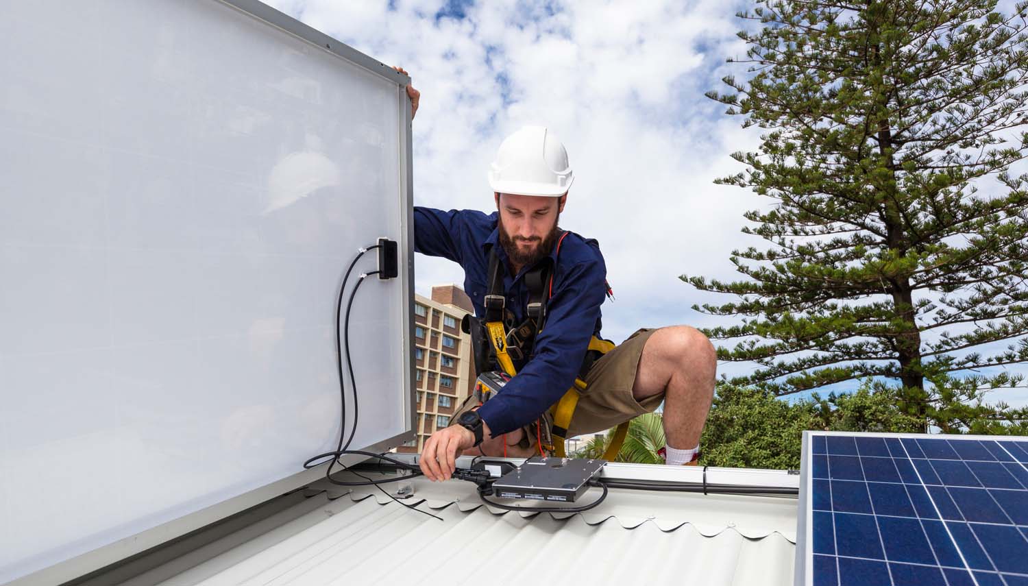 worker on a roof installing solar panels for a san antonio homeowner