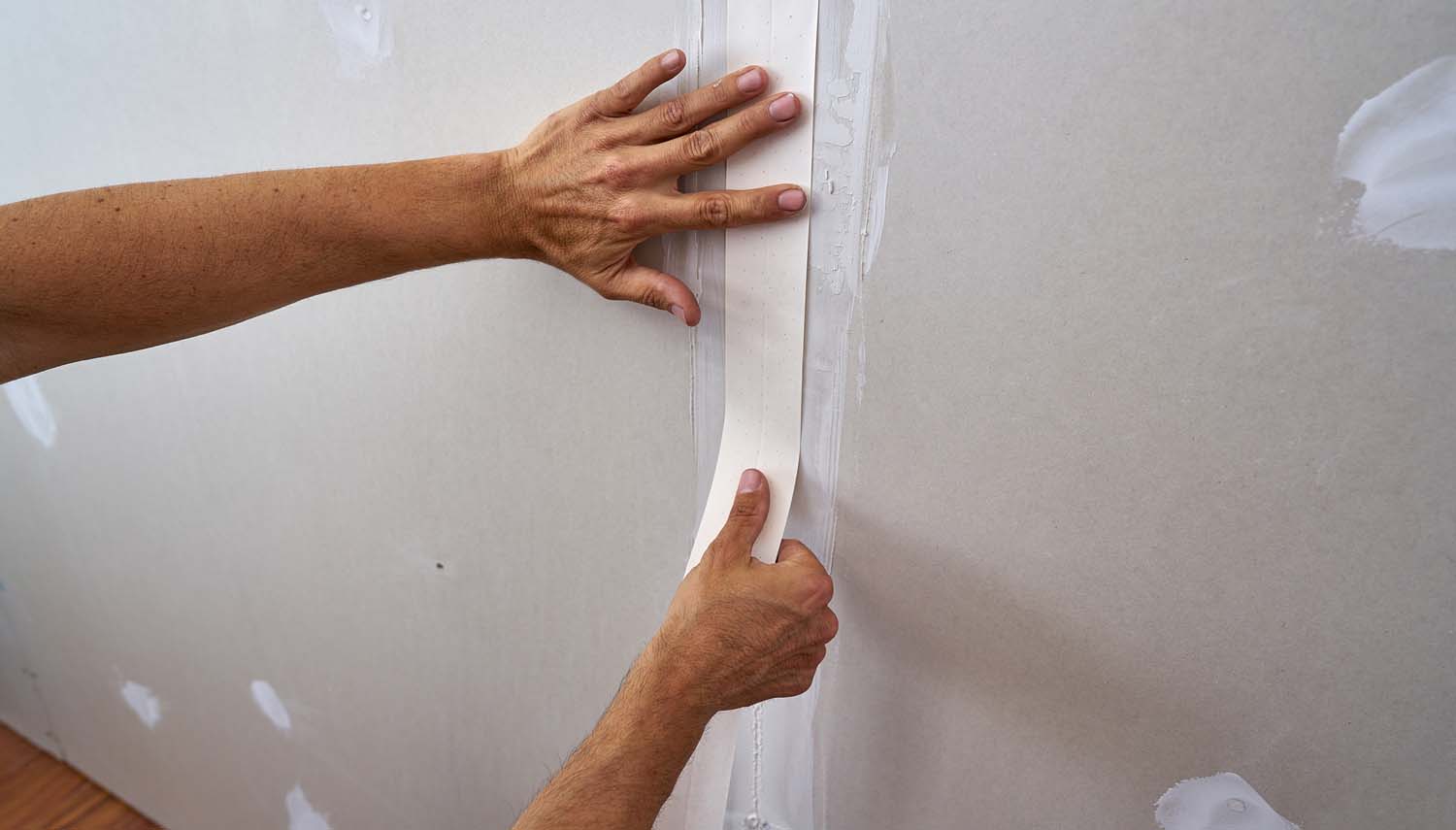close-up of a contractor repairing drywall with a patch san antonio