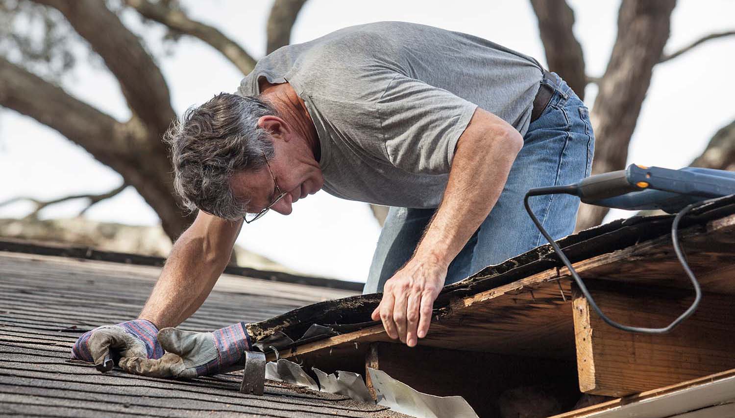 contractor inspecting roof checking shingles around the chimney