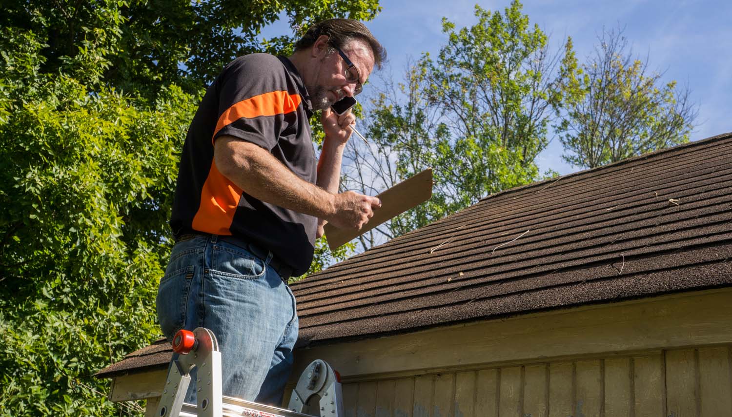 roofing contractor prepares a quote for repairing the leaking roof