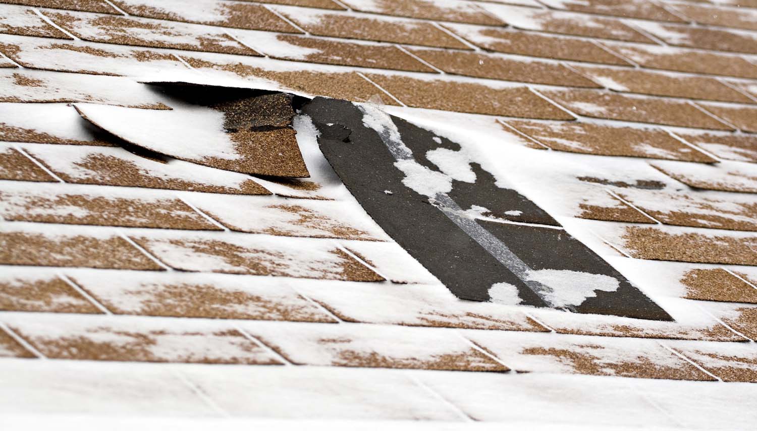 close up view of a roof and shingles hta have been torn off during a storm