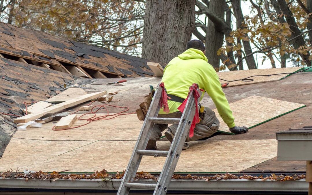 roofing contractor working on replacing roof shingles after a storm