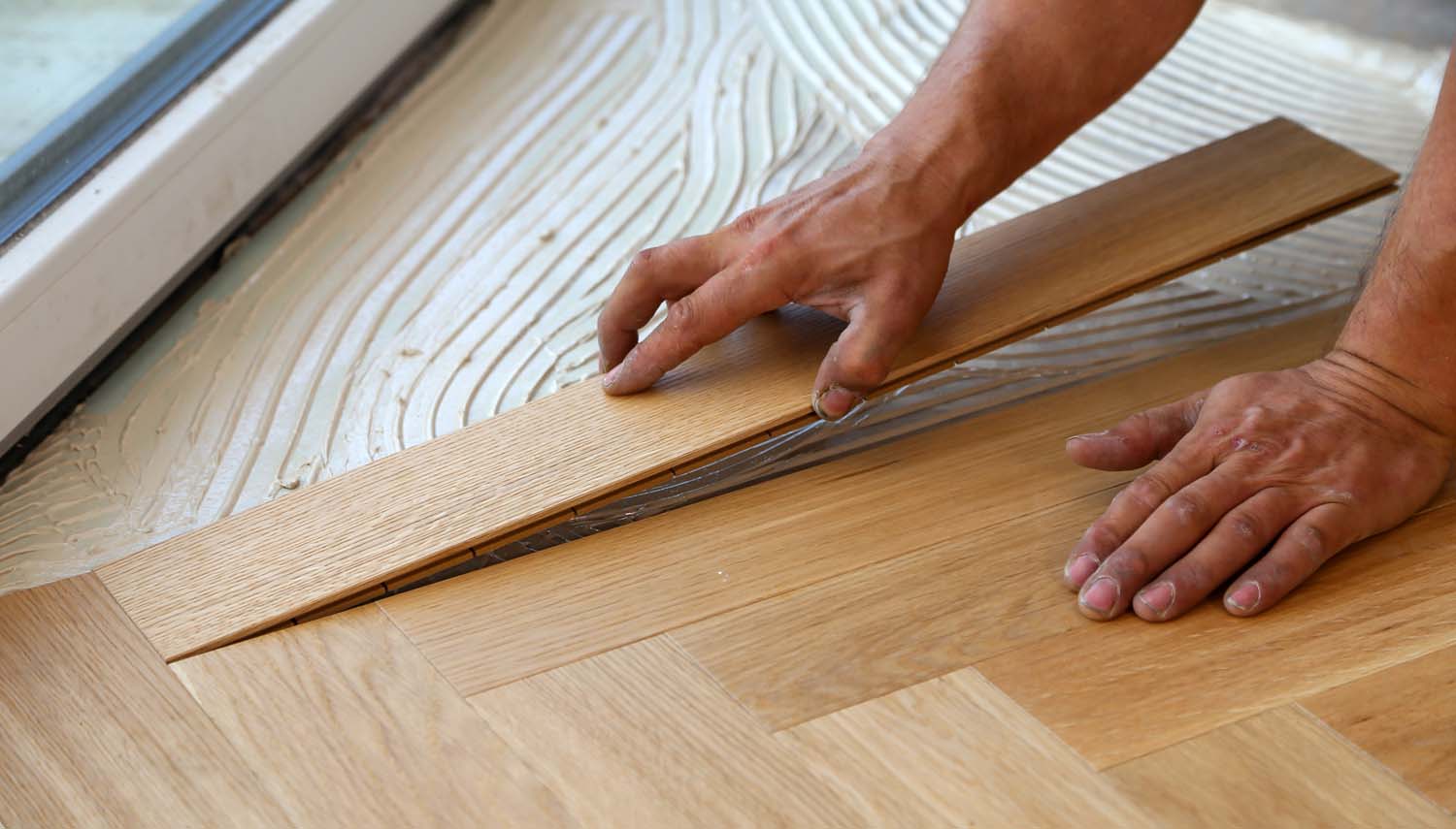 close up of contractor hands install laminate flooring san antonio home