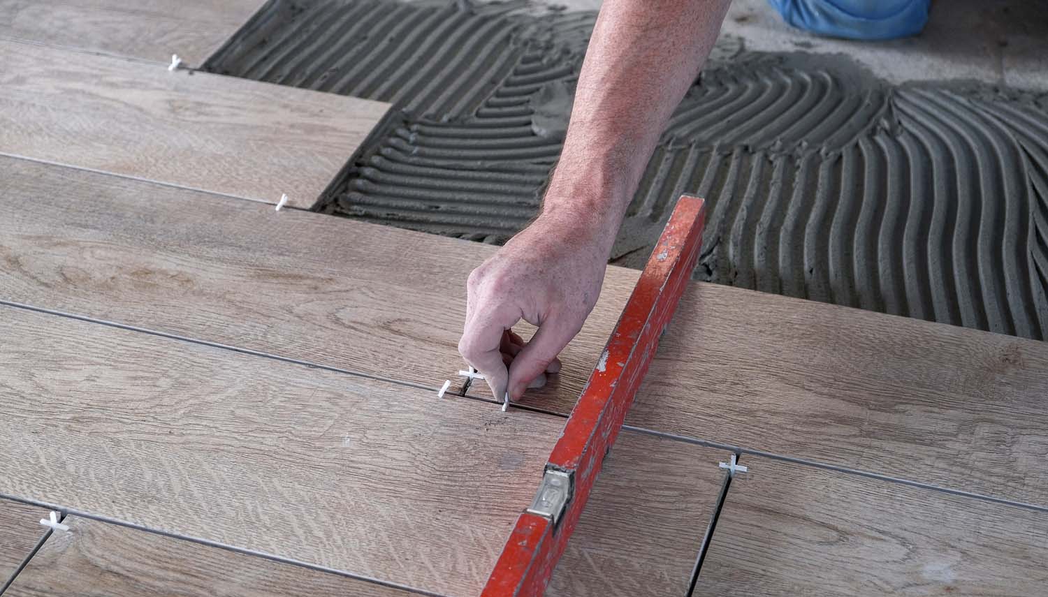 contractor with a trowel adding sections of laminate to flooring work in san antonio