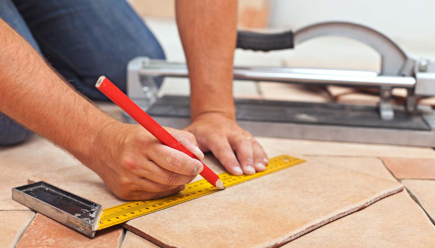 contractor is marking a line on tile during installation for san antonio homeowner