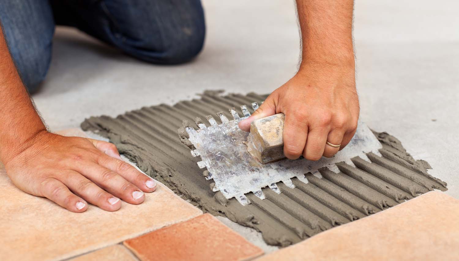 tiling contractor is installing tile with trowel in San Antonio