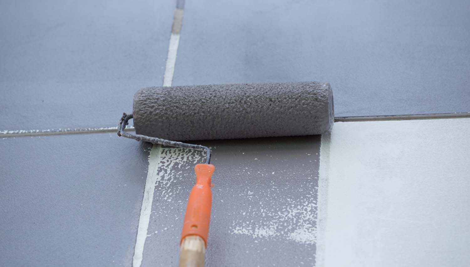 roller with grey paint on an interior wall for a homeowner in san antonio
