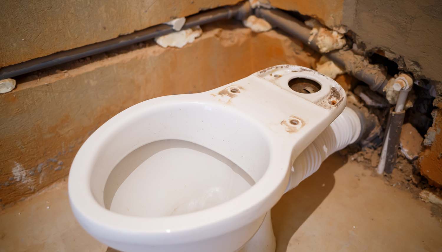 image of a bathroom with the wall open showing pipes and leak